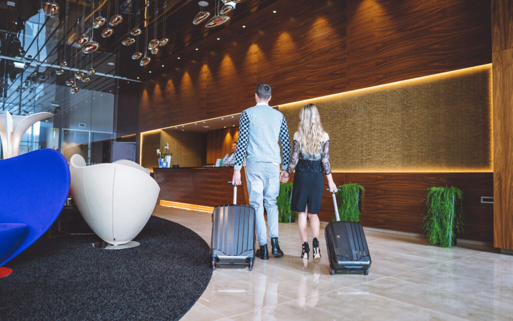 Hotel lobby with a couple walking in. Lobby shows the effects of feature lighting on ambience.