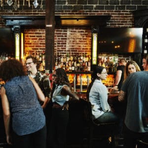 Group of friends sharing drinks in busy bar