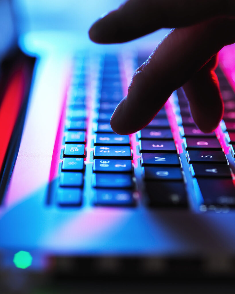 Man typing at his laptop computer at night