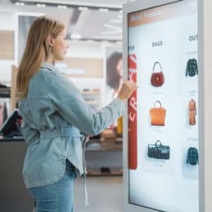 Customer Using Floor-Standing LCD Touch Display while Shopping in Clothing Store