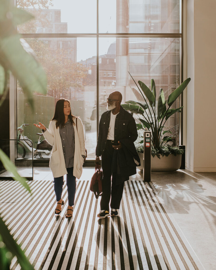 People walking into an office lobby which has access control systems.