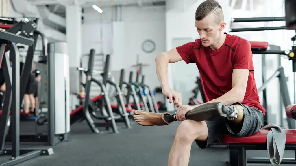 Man with prosthetic leg sitting in the gym as part of health service